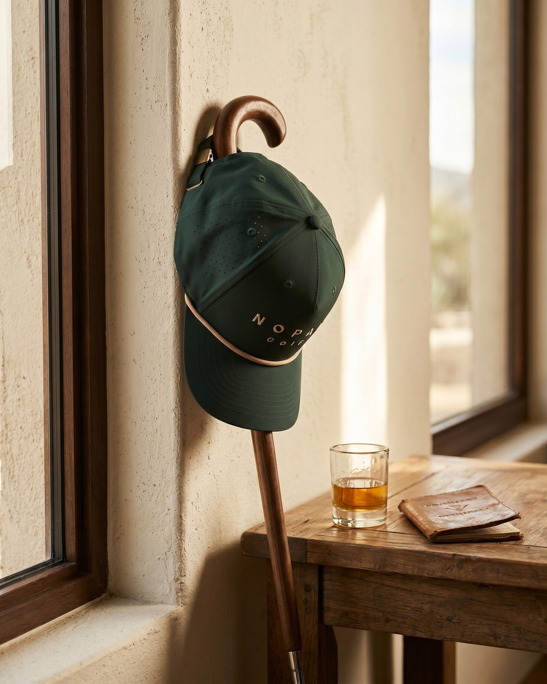 Gorra Nopal Verde colgada de un bastón junto a una ventana