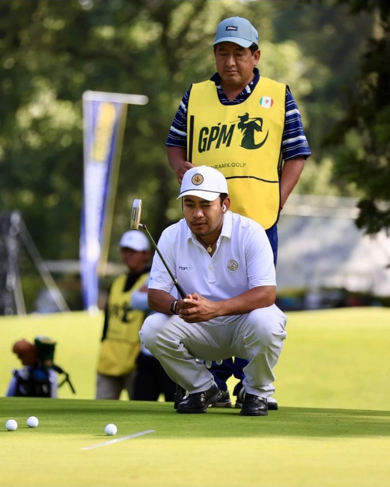 Jugador con gorra blanca leyendo la línea de un putt